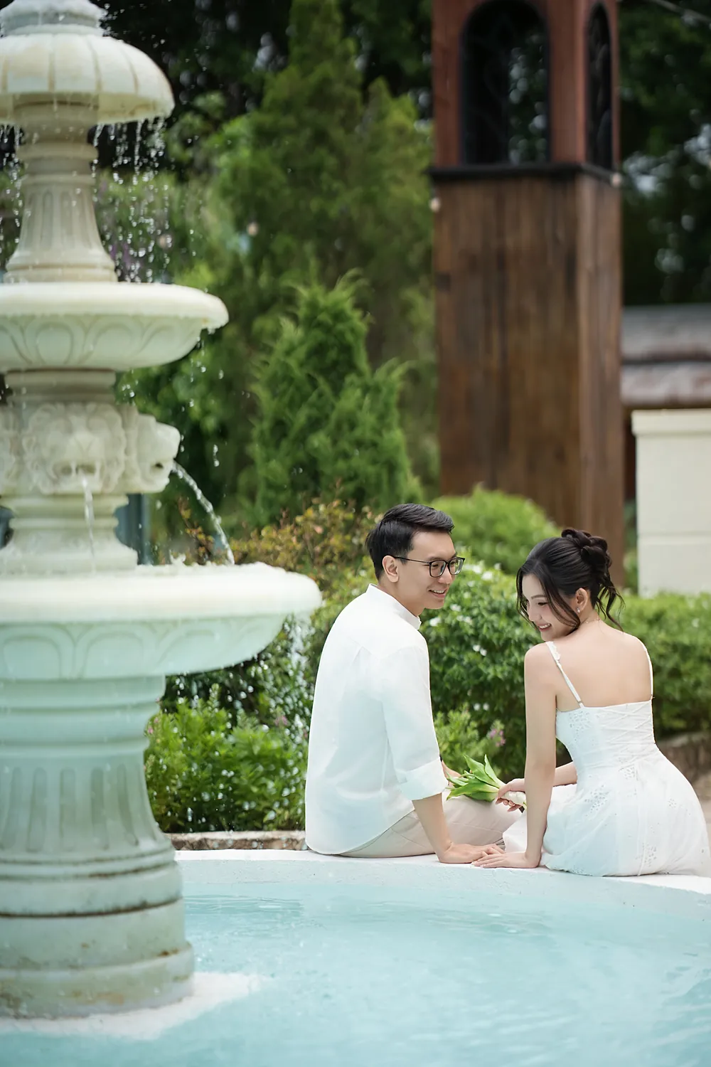 Cô dâu chú rể ngồi bên đài phun nước