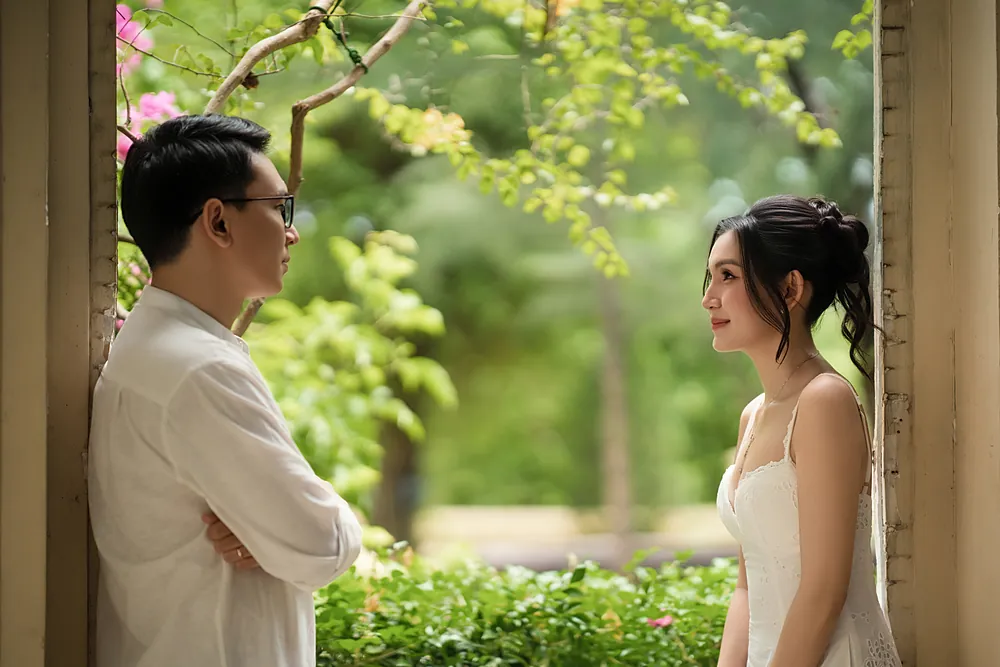 Chú rể và cô dâu nhìn nhau qua ô cửa
