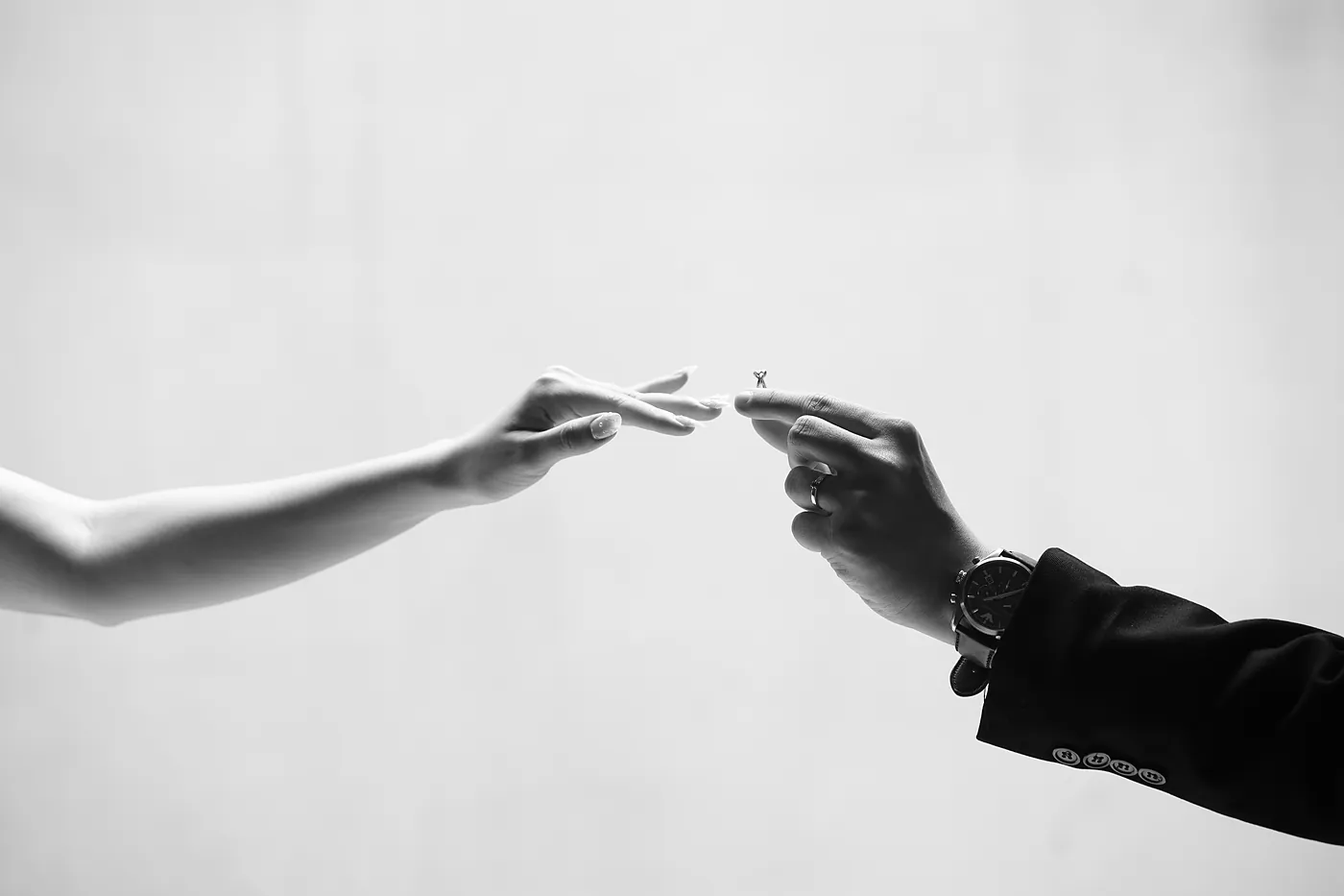 Hai bàn tay chạm nhau cùng chiếc nhẫn cưới
